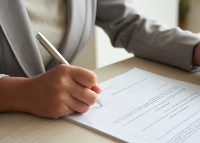 Close-up image of enterrepneur reading agreement before singing it